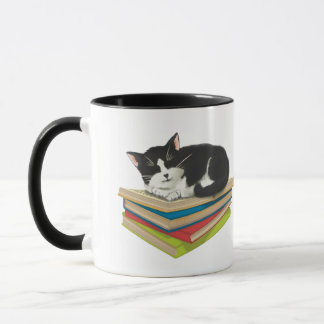 Cat sleeping on books mug