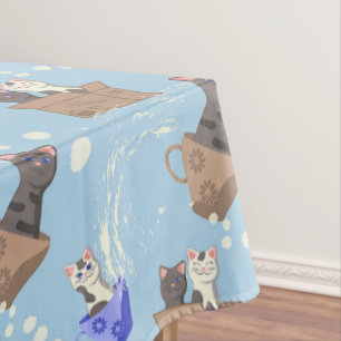 Cats in box and milk drops on blue tablecloth