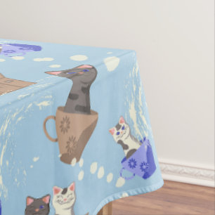 Cats in box and milk drops on blue tablecloth