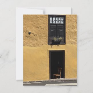 Chair in Door Opening of Yellow Building