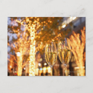 Champagne glasses toasting Christmas on city Holiday Postcard