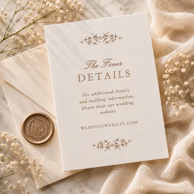 An enclosure card with copper letterpress ink rests atop beige textured material. It's surrounded by some foliage and a copper-colored wax seal.