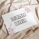 Cherry Blossoms and Chemistry: A Unique Thank You<br><div class="desc">This picture is a creative way of saying “Thank You” using elements from the periodic table. It has a white background with pink cherry blossoms on the left side and scattered petals throughout. There are two rows of black squares, each containing an element from the periodic table, including its symbol,...</div>