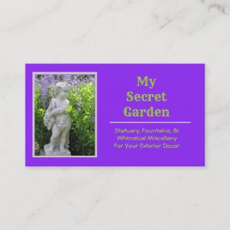 CHERUBIC STATUE IN GARDEN WITH LAVENDER FLOWERS  
