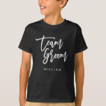 Chic Trendy Brush White Script Team Groom T-Shirt<br><div class="desc">T-shirt featuring the words "Team Groom" in chic trendy brush white script that's perfect for the ring bearer. For other matching items see here https://www.zazzle.com/collections/119250194970828530?rf=238364477188679314 Personalize it by replacing the placeholder text. For more options such as to change the font and it's size, color or the spacing between letters click...</div>