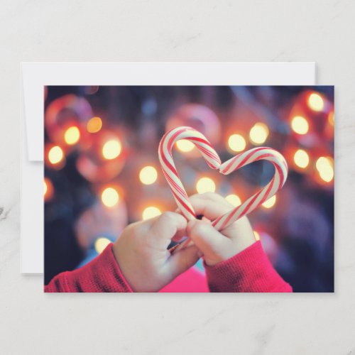 Child holding Christmas candy with heart shape Holiday Card