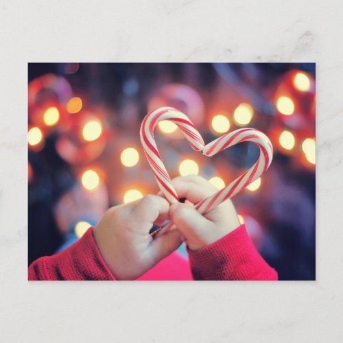 Child holding Christmas candy with heart shape Holiday Postcard