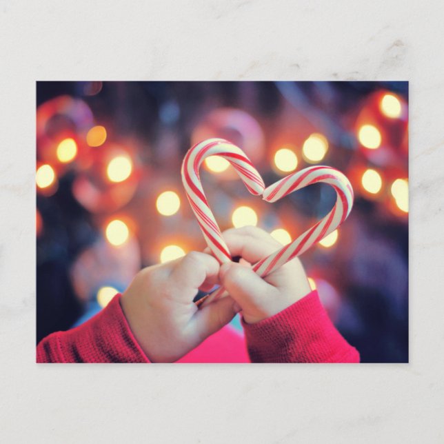Child holding Christmas candy with heart shape Holiday Postcard (Front)
