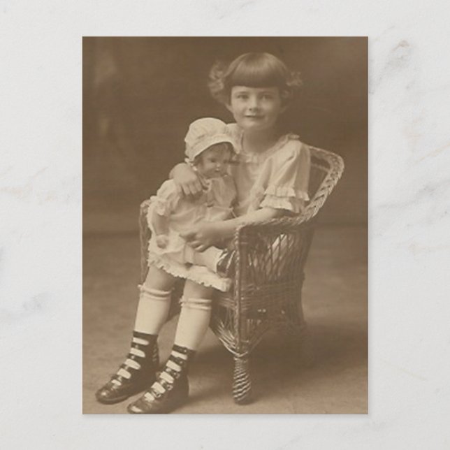 child sitting in chair holding doll post card (Front)