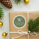 Christmas Greenery Pattern Address Classic Round Sticker<br><div class="desc">This festive Christmas return address sticker features an olive green circle on a watercolor pattern of winter greenery, including evergreen pine trees and holly sprigs with red berries, on a white background. Personalize the design with your monogram initial and family name in white serif font, with your address below in...</div>