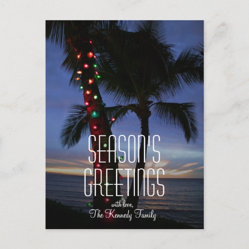 Christmas lights adorn a palm tree at sunset holiday postcard