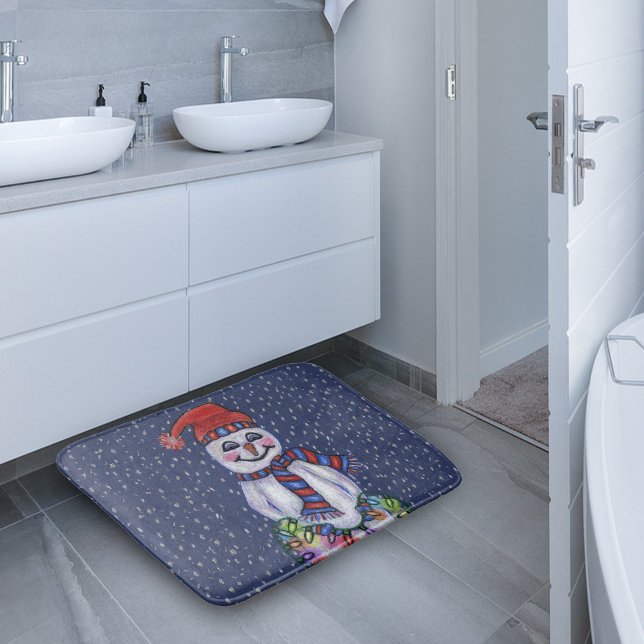 Christmas Lights Smiling Snowman Snowflakes Bathroom Mat (Snowman red blue hat scarf holding glowing Christmas lights in snow on dark blue bath mat.)