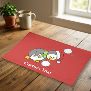 Christmas penguin getting a snow ball cloth placemat