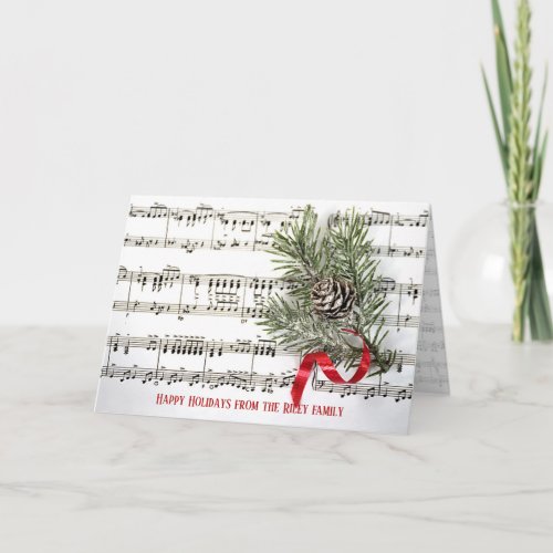 Christmas pine with red ribbon on music card