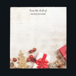 Christmas Themed Items on a Rustic Wooden Board Notepad<br><div class="desc">Personalized notepad with a rustic photograph. A light brown wooden board with various Christmas elements along the bottom. Christmas gifts,  a star,  a gold Christmas tree,  winter hat,  reindeer,  baubles and some holiday fruits.</div>