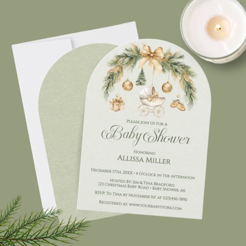 Elegant winter baby shower invitation featuring an arched watercolor pine bough with hanging nursery ornaments and swirly calligraphy