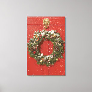 Christmas wreath hanging on a door canvas print
