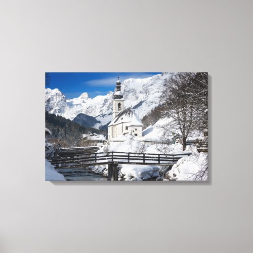 Church in the snow with Alps mountains Canvas Print