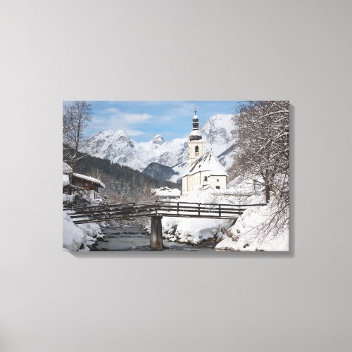 Church in the snow with Alps mountains in winter Canvas Print