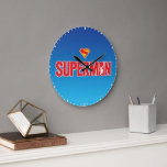 Classic Superman Bold Logo Large Clock<br><div class="desc">Bring timeless superhero energy to your style with this striking Superman design! Featuring the bold red “SUPERMAN” text with a silhouette of the Man of Steel heroically posed within the lettering, this artwork pops against a sleek gradient blue background. Topped with the iconic red and yellow “S” shield, it’s a...</div>