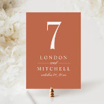 Classic Terracotta Wedding Table Number Card<br><div class="desc">A warm terracotta background and bold white serif typography bring earthy, modern elegance to this wedding table number card. The couple's names and wedding date are displayed in a clean typographic layout for a sophisticated monogram centerpiece. The couple's names, date, and table number are easy to personalize. Each table number...</div>
