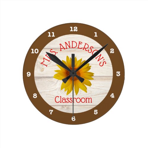 Classroom Rustic Daisy Teacher Round Clock - This teacher's classroom clock features a rustic farmhouse theme with yellow daisies on a shiplap background. Red text allows you to add the teacher's name. A perfect accent to any classroom.