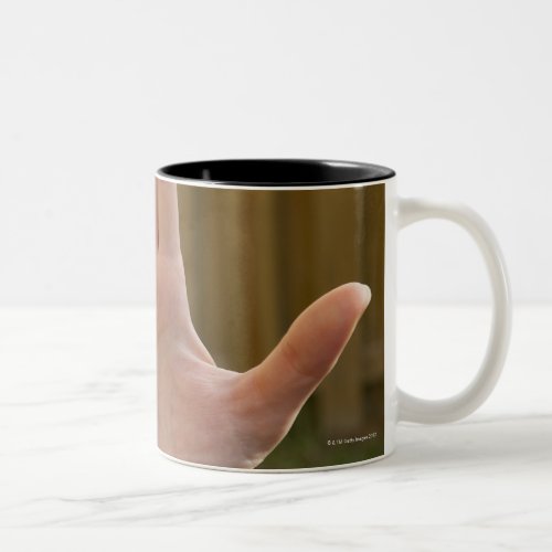 Close_up of a womans hand making a hand sign Two_Tone coffee mug