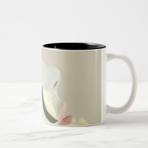 Close_up of a young woman wearing a facial mask Two_Tone coffee mug
