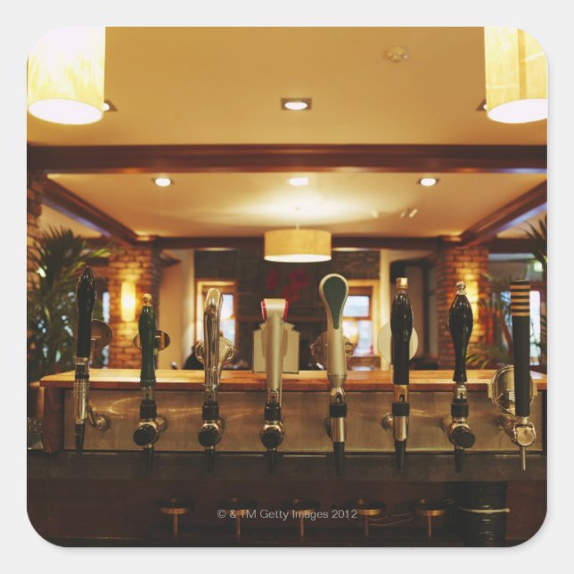 Close-up of beer taps in bar square sticker (Front)