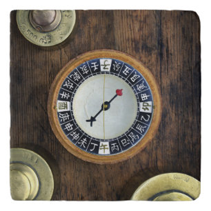 Close Up Of Chinese Compass And Gold Weights Trivet