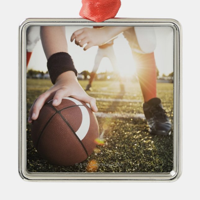 Close up of football center preparing to snap metal ornament (Front)