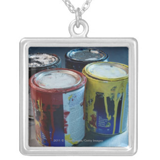 Close-up of four paint cans silver plated necklace