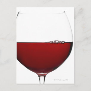 Close up of glass of red wine on white postcard
