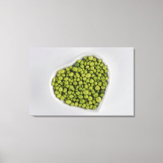 Close-up of green pebbles in a heart shape bowl canvas print