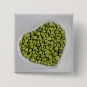 Close-up of green pebbles in a heart shape bowl pinback button
