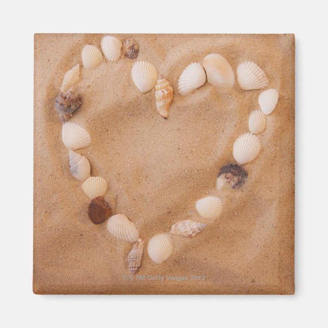 Close up of heart shape made of shells on sand magnet (Front)