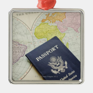 Close-up of passport lying on map metal ornament