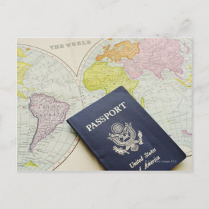 Close-up of passport lying on map postcard