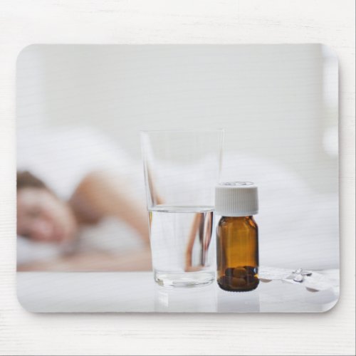 Close up of pill bottle with sick woman in mouse pad