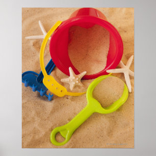 Close up of toys on sand poster