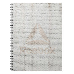 Close-up photo of Reebok logo on wall Notebook