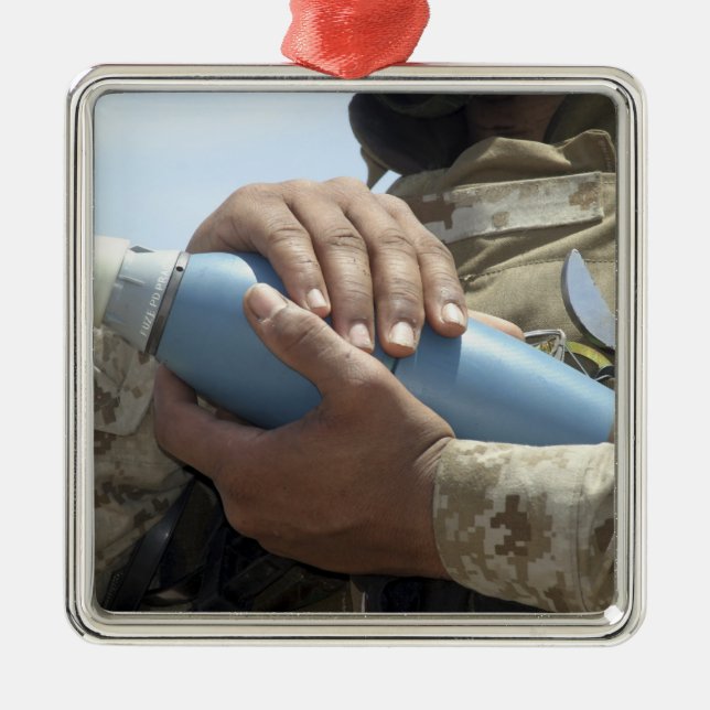 Close-up view of a soldier cradling a munition metal ornament (Front)