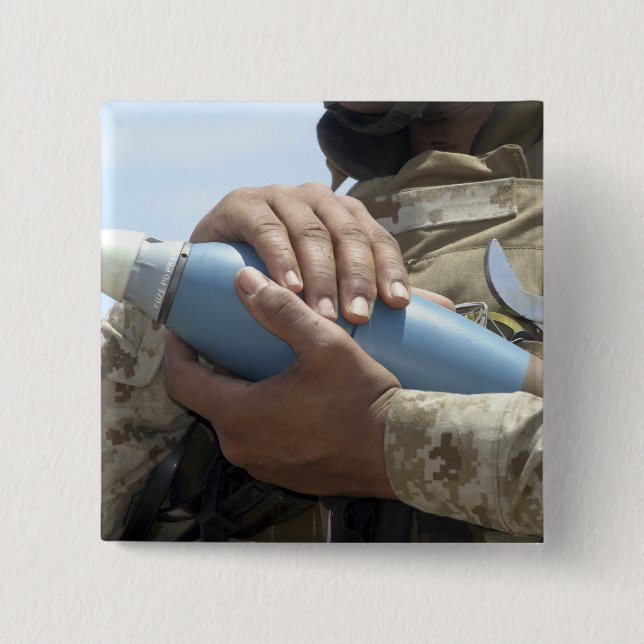 Close-up view of a soldier cradling a munition pinback button (Front)