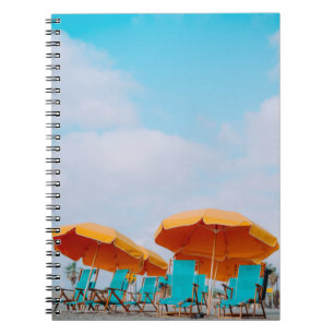 Closeup photo of lounger chairs and beach umbrella notebook
