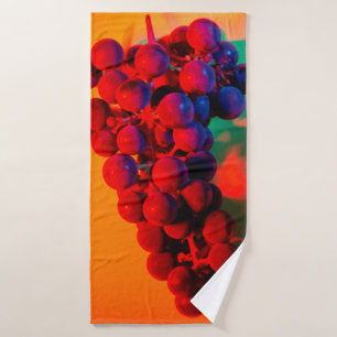 Cluster of blue grape in orange neon light. Food b Bath Towel