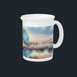 Coastal Cottage at Sunrise Marsh Beverage Pitcher<br><div class="desc">This peaceful illustration captures a charming blue coastal cottage nestled beside a calm marsh, bathed in the soft light of sunrise. The artwork evokes a sense of stillness and solitude, with gently swaying reeds, a weathered dock, and mirrored reflections in quiet waters. Warm pastel tones blend seamlessly with cool blues,...</div>