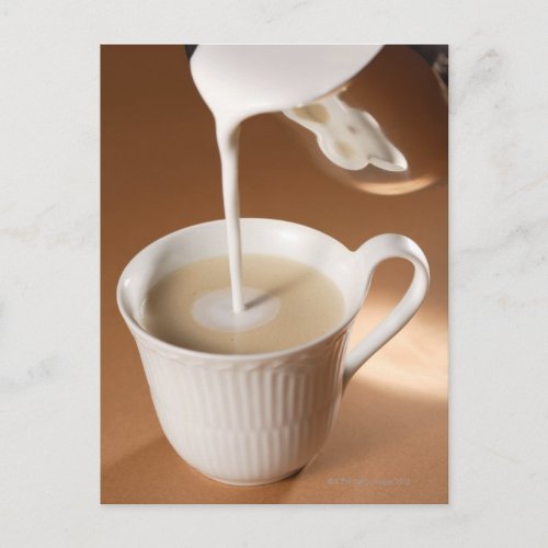 Coffee with milk being poured in postcard