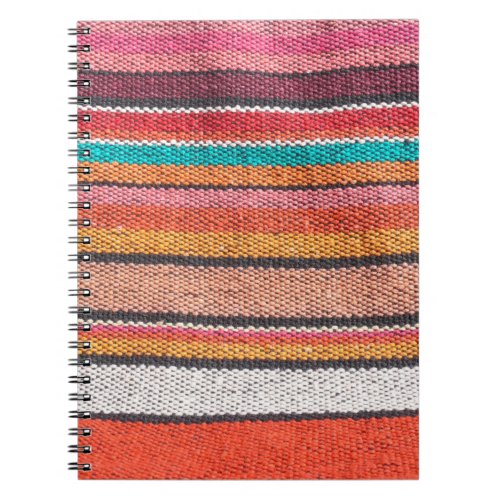 Colorful mexican peruvian style rug surface close notebook