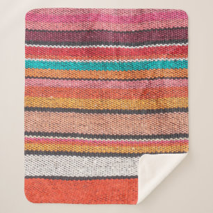 Colorful mexican, peruvian style rug surface close sherpa blanket