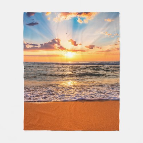 Colorful ocean beach sunrise with deep blue sky an fleece blanket